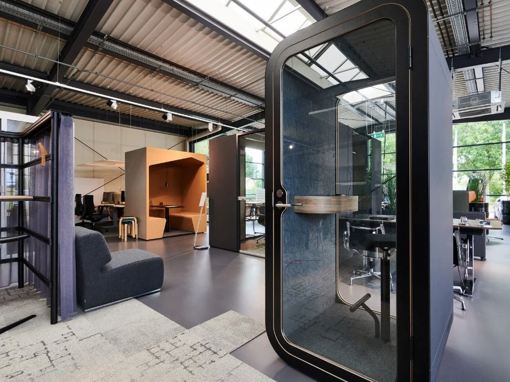 Modernes Kombibüro mit Zellen für Einzelarbeit, Büroarbeitsplätzen und Sitzlounge.