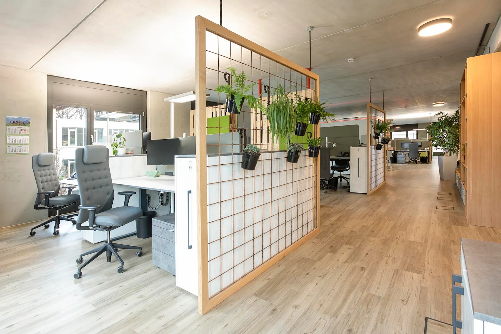 Großraumbüro mit warmen Holztönen und verschiedenen Arbeitsplatzinseln.