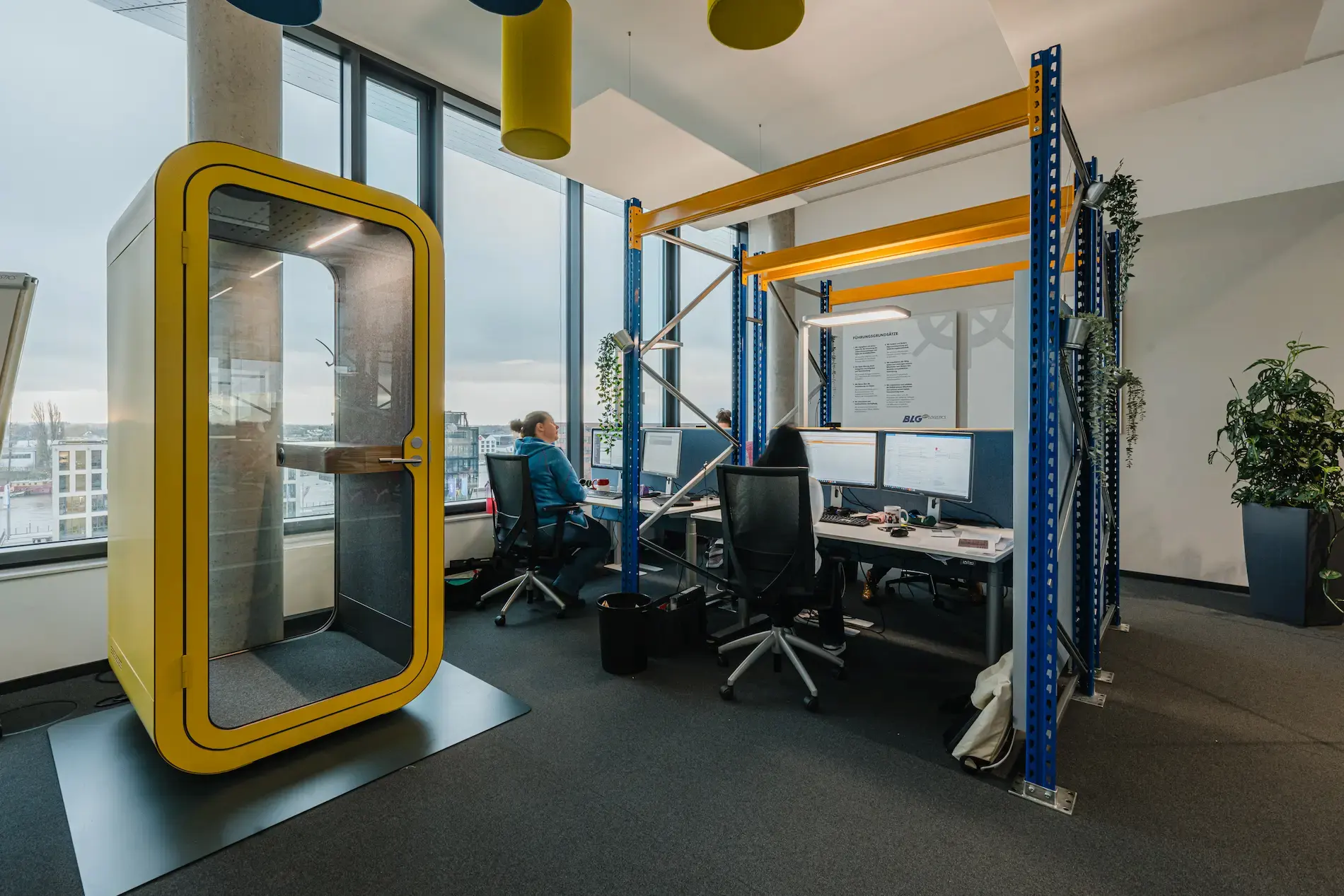 Ein Großraumbüro in Kombination mit einem Zellenarbeitsplatz für konzentrierte Einzelarbeit.